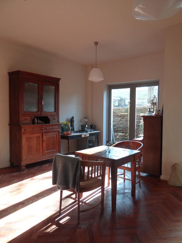 A kitchen with wooden cabinets, a dining table, and chairs.