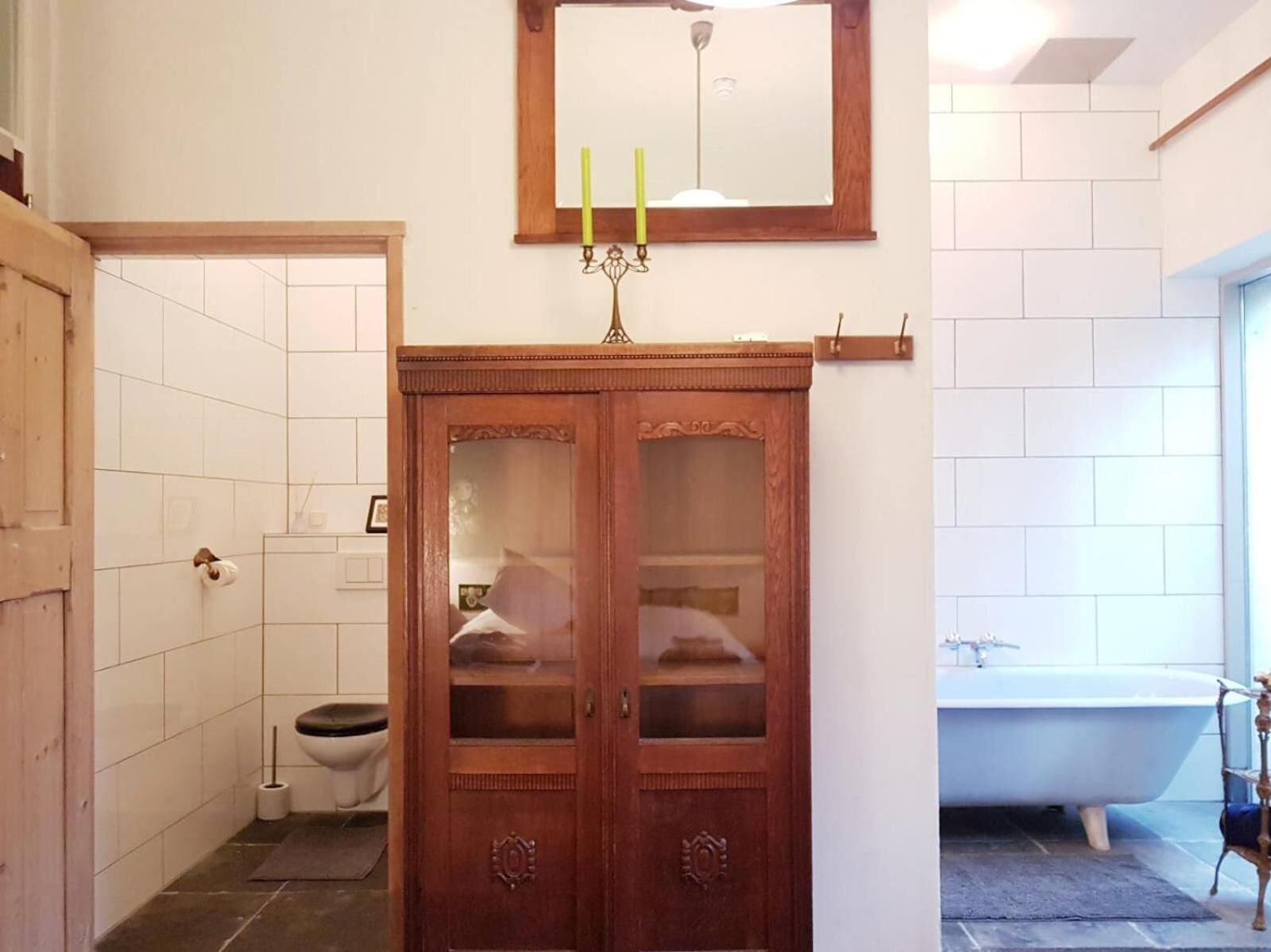 A bathroom with a wooden vanity, a toilet, and a bathtub.