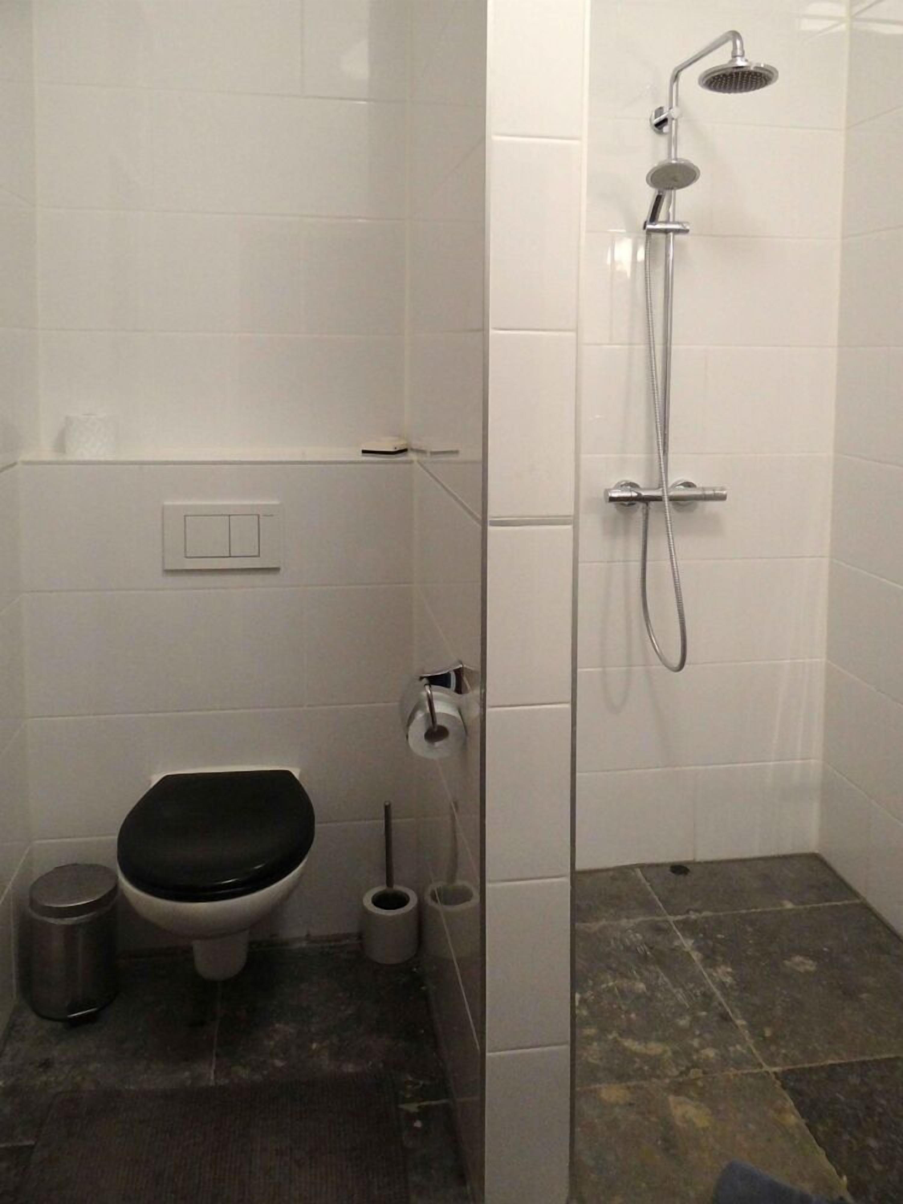 Un baño pequeño y cerrado con inodoro, bidé y ducha.