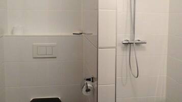 Un baño pequeño y cerrado con inodoro, bidé y ducha.