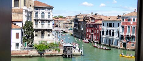 Un canal bordé de gondoles, de bâtiments historiques et d’une tour.