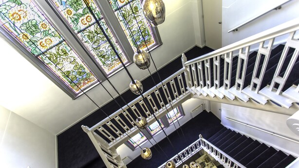 A staircase with white railings and black steps, leading to a lower level. - Rijksmonument Hotel de Sprenck (Middelburg)