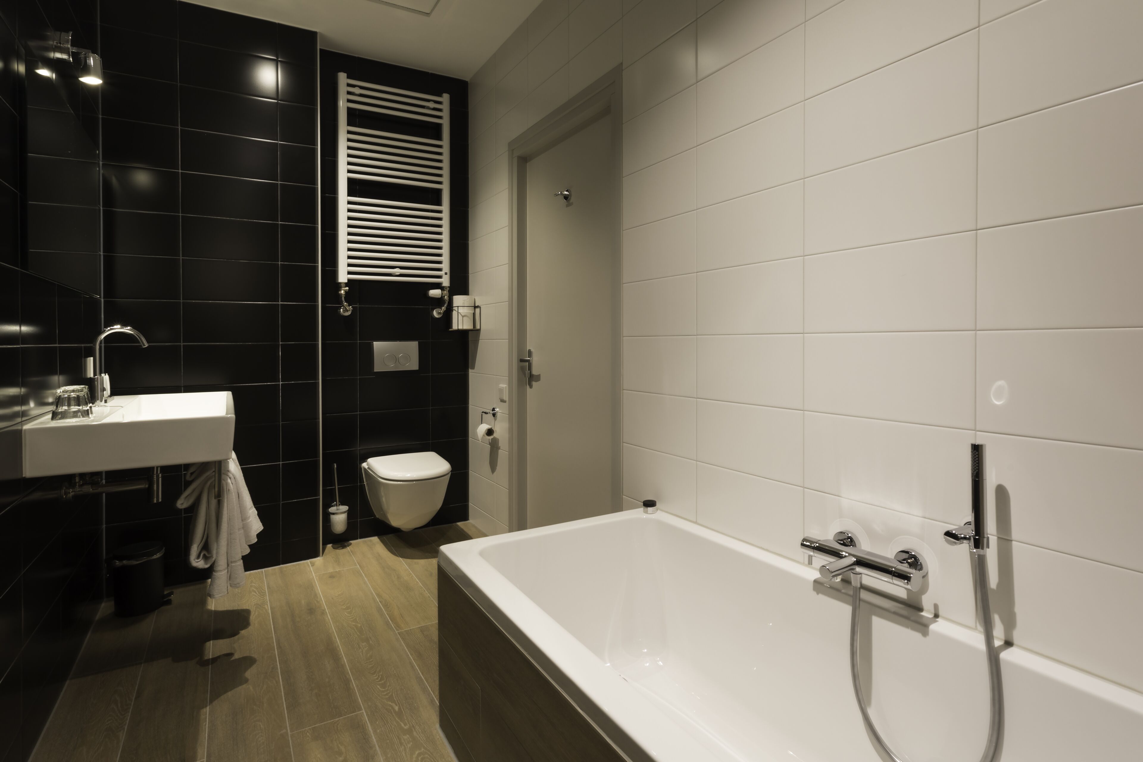 A modern bathroom with a bathtub, toilet, and sink.
