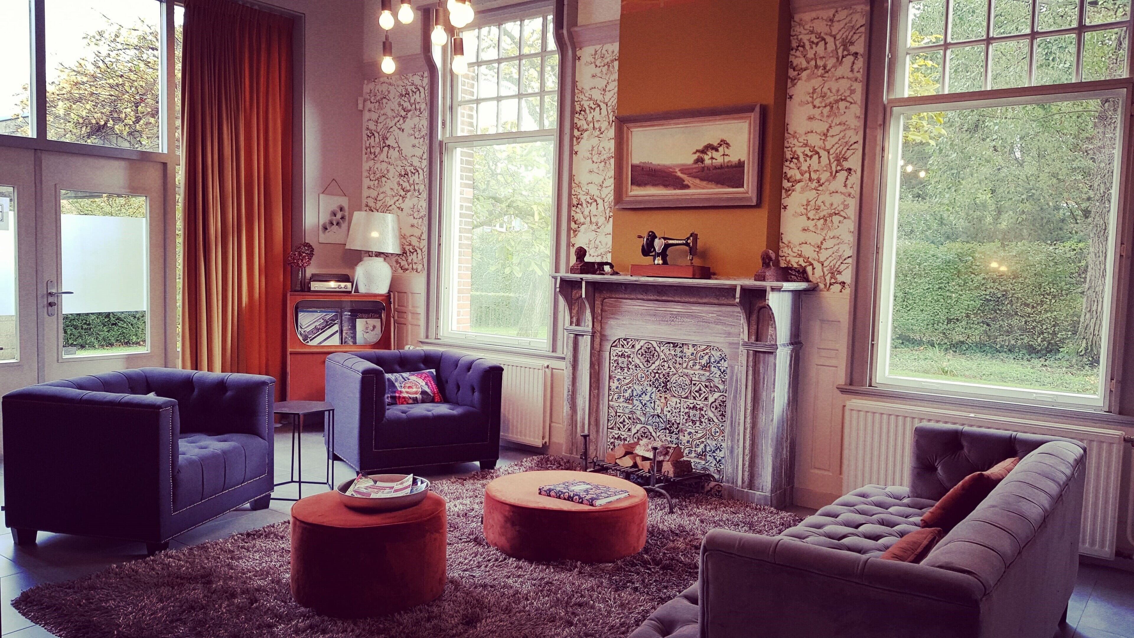 A cozy living room with a fireplace, two sofas, a coffee table, and a vintage television set.