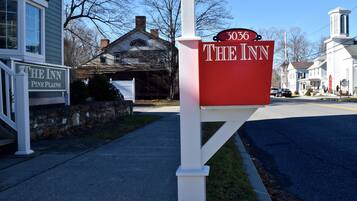 Un buzón rojo con el número 3036 y el texto "THE INN" en un poste blanco.