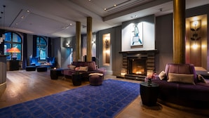 A modern lounge area with a fireplace, comfortable seating, and a blue patterned rug. - TORTUE HAMBURG (Hamburg)