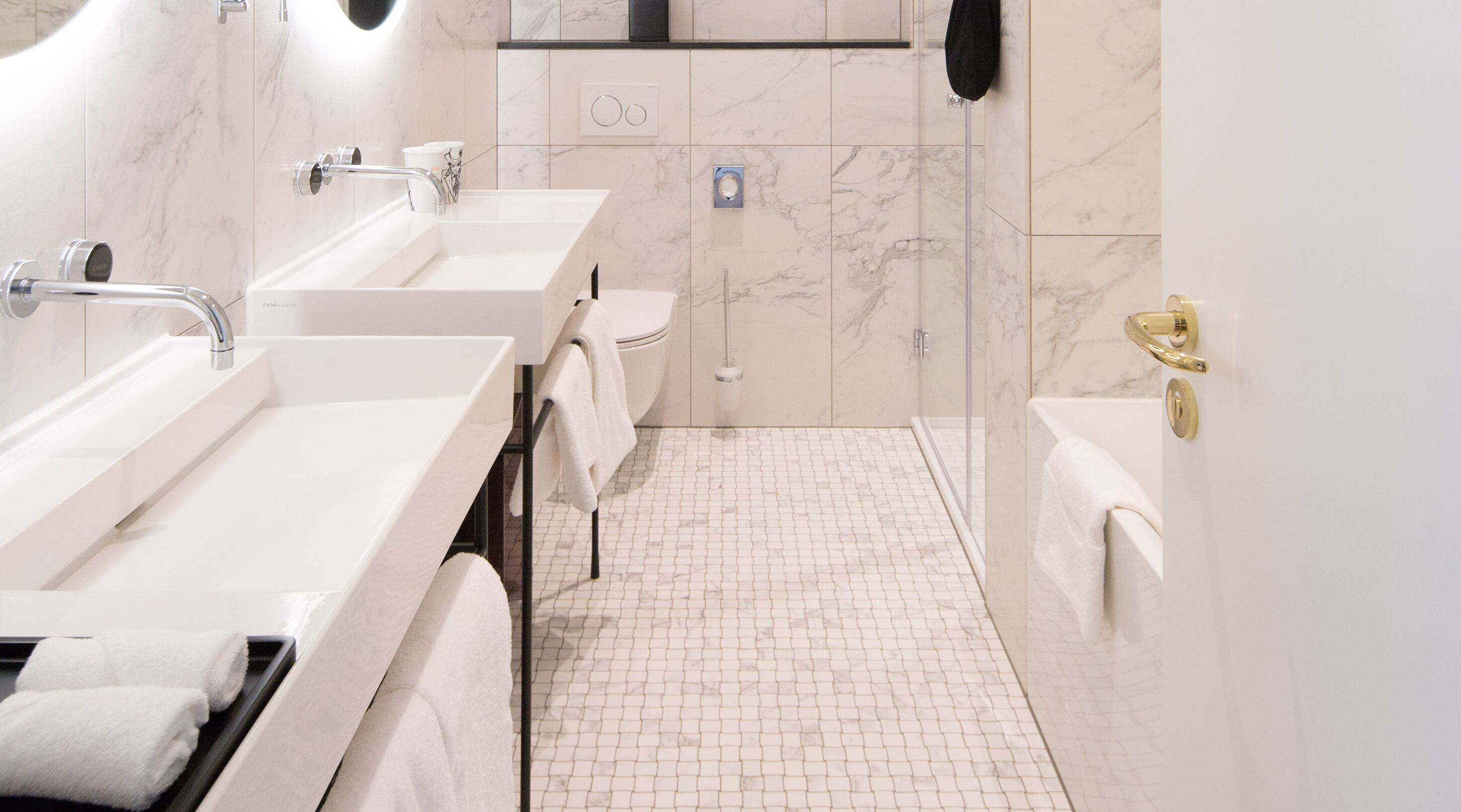A modern bathroom with three sinks, a toilet, a shower, and a bathtub.