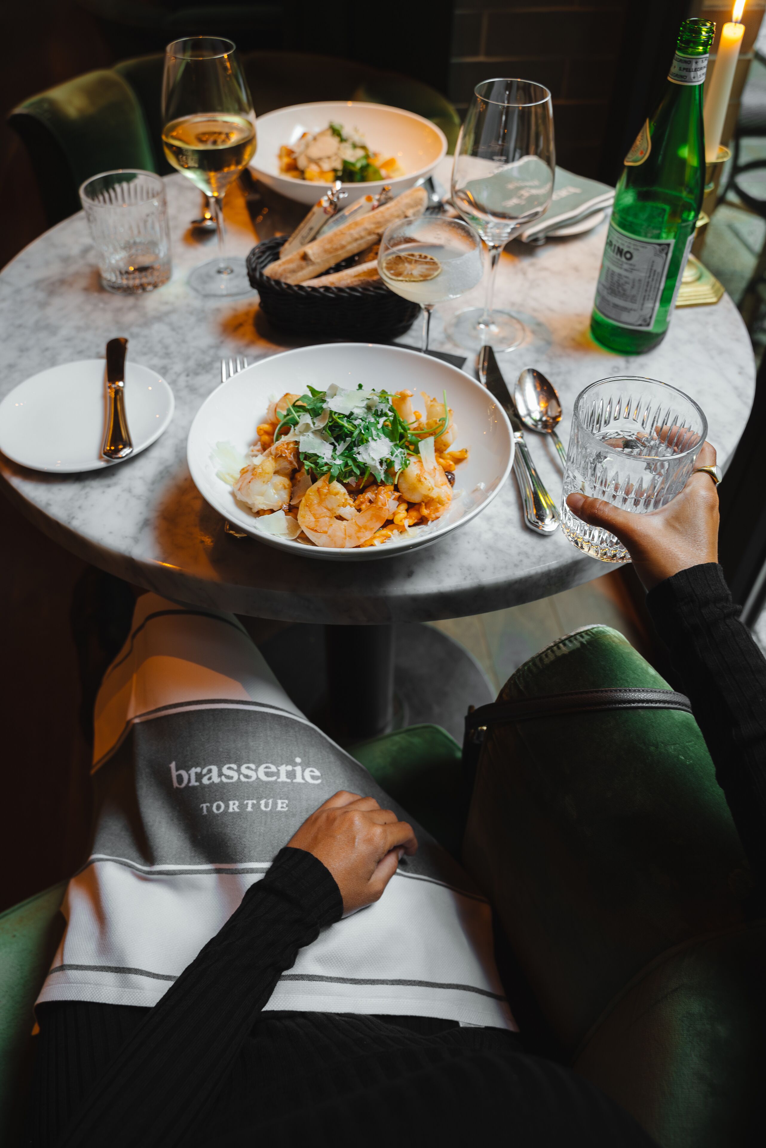 A dining table with plates of food, glasses, and cutlery.
