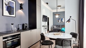 A modern kitchen with a built-in oven, a dining area with a round table and chairs, and a living area with a sofa and a coffee table. - TORTUE HAMBURG (Hamburg)