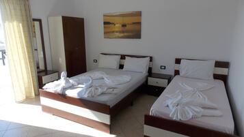 Una habitación de hotel con dos camas, un cuadro en la pared y un espejo.