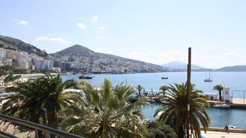 A coastal cityscape with a marina, palm trees, and buildings along the waterfront.