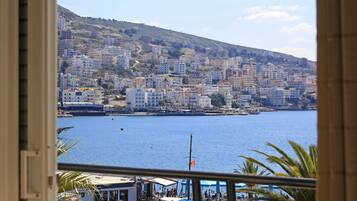 A coastal cityscape with buildings along the waterfront, a clear sky, and a view of the sea.