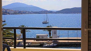 A coastal view with boats, a mountain, and a cityscape. - Hotel Real (Sarandë)