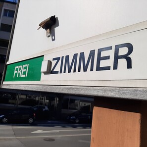 A building with a sign that reads "FREI ZIMMER" and a bird perched on the sign. - Hotel Emmental (Thun)