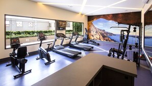 Een moderne sportschool met loopbanden, hometrainers en krachtapparaten.