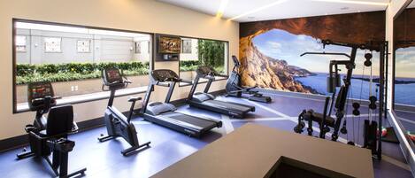 A modern gym with treadmills, stationary bikes, and weight machines.