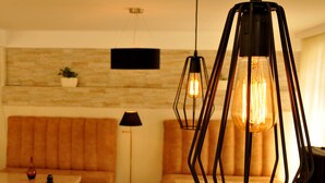 A modern living room with a sofa, a coffee table, and two pendant lights. - BM Plaza (Borjomi)