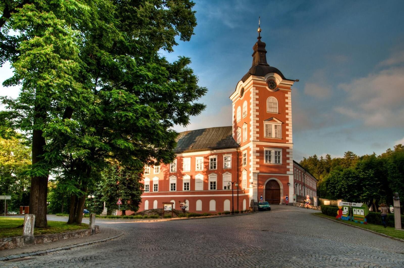 A historic red brick building with a prominent tower and arched windows.