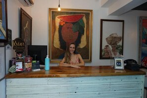 Ein Empfangstresen mit einem gerahmten Gemälde darüber, ein Schild für 'Kviar Sports Bar & Casino' und ein Telefon auf der Theke.
