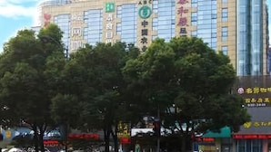 A hotel with multiple floors, large windows, and a prominent sign with Chinese characters. - Hanting Hotel (Shaoxing)