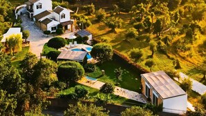 A large, white house with a swimming pool and solar panels, surrounded by lush greenery. - Villa Claire Corfu (Corfu)
