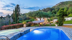 A swimming pool with a hammock and potted plants. - Villa Claire Corfu (Corfu)