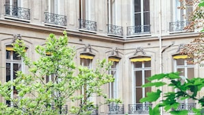 Un edificio con varias ventanas, algunas con toldos amarillos, y barandillas de hierro ornamentales en los balcones.