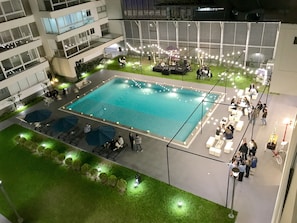 A rooftop pool area with a stage for live music, surrounded by seating and lounge areas. - Moon Luxury Apartments (Santiago de Surco)