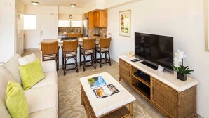Un salon comprenant un canapé, une table basse, un téléviseur et un ventilateur de plafond.
