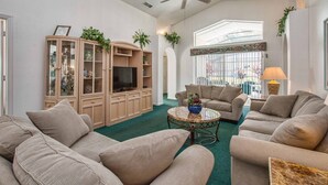 Ein Wohnzimmer mit einem großen Schrank, zwei Sofas, einem Couchtisch und einem Deckenventilator.