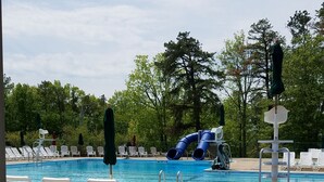 A swimming pool with a slide, lounge chairs, and a covered area. - Mountain/lake community in Poconos,PA (Lackawaxen)