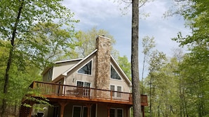 A two-story cabin with a stone chimney, a wooden deck, and a covered porch. - Mountain/lake community in Poconos,PA (Lackawaxen)