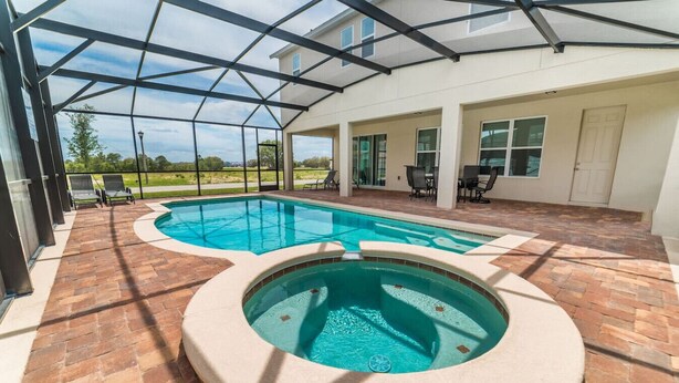 A covered outdoor swimming pool with a hot tub, surrounded by a patio area with brick flooring and outdoor furniture. - Spanish Sunset - Private Pool/Spa & 24/7 Support (Davenport)