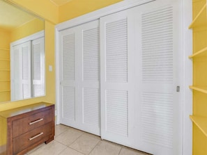 A room with a yellow wall, a wooden dresser, and a white closet with louvered doors. - Suite Paradise! Enjoy fiery sunsets, Free WiFi, Full Kitchen–Waikīkī Shore #1008 (HONOLULU)