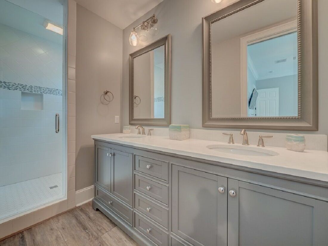 A bathroom with a double vanity, two sinks, and a large mirror.