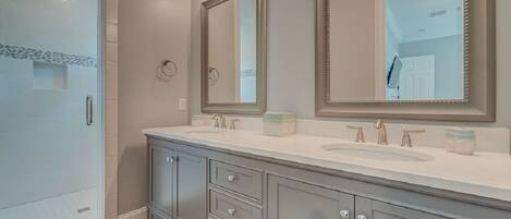 A bathroom with a double vanity, two sinks, and a large mirror.