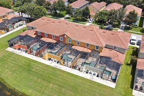 An aerial view of a residential building with multiple roof terraces, each with a pool and outdoor seating.