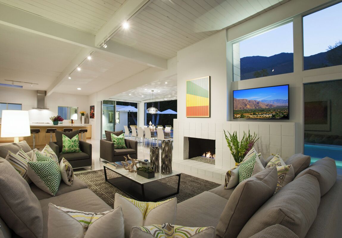 A modern living room with a fireplace, comfortable seating, and a large TV.