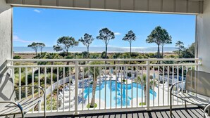 Ein Balkon mit Blick auf Pool und Strand.