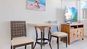 Una habitación con un armario de madera, televisión, un cuadro de una tortuga y una silla.