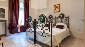 Une chambre à coucher avec un lit à baldaquin, un radiateur, une fenêtre avec des rideaux et un tableau accroché au mur.