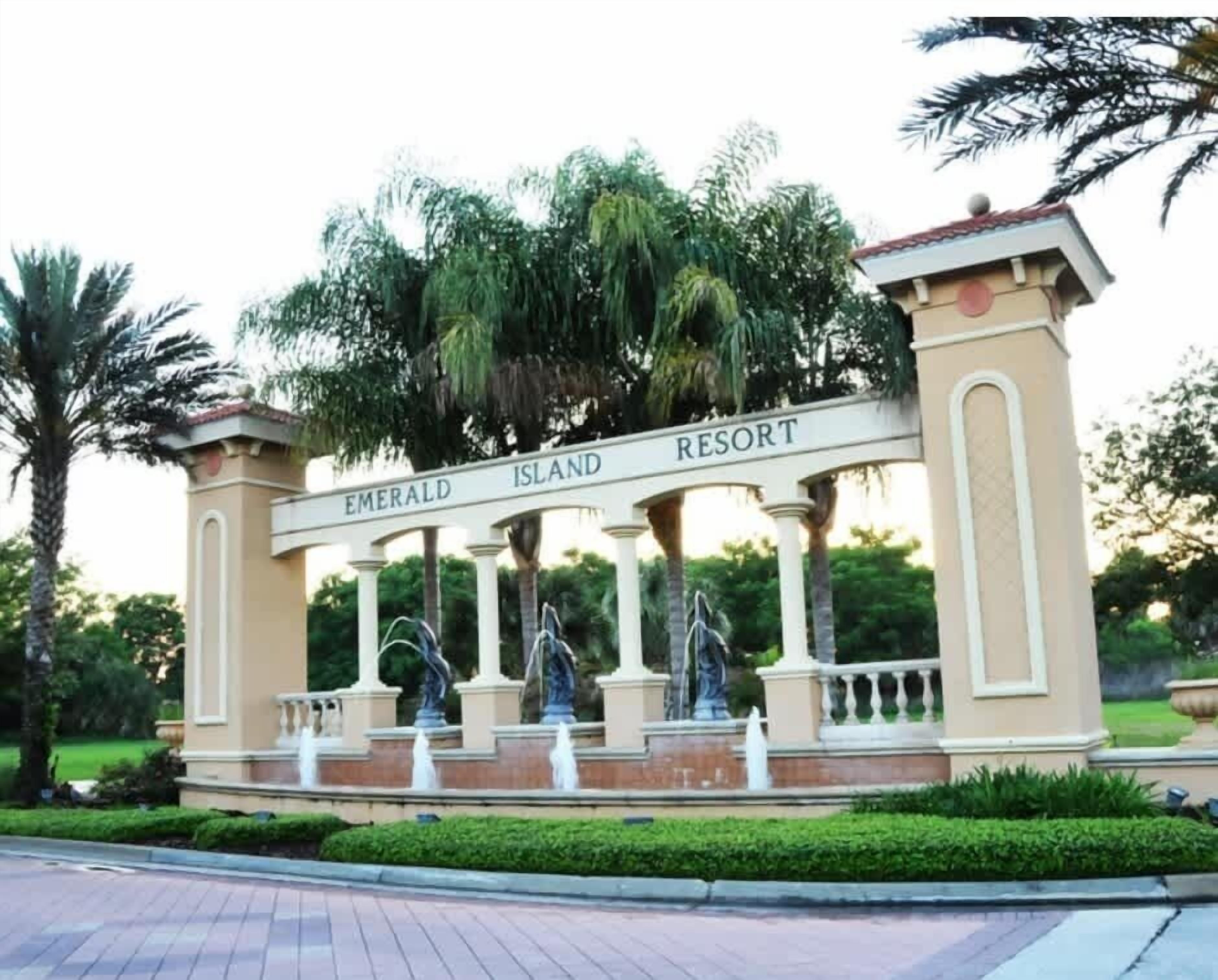 Een bord voor Emerald Island Resort, met een klassieke architectuur, inclusief kolommen en beelden.