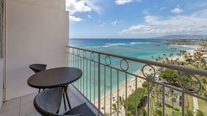 Ein Balkon mit Blick auf Strand und Meer.