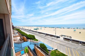 A beach view from a balcony with a wooden boardwalk, lounge chairs, and a pool. - Ocean Hideaway 207-Oceanfront 18th St, Free WiFi, Elev, W/D, AC (Ocean City)