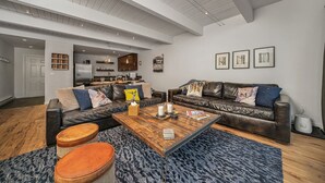 A modern living room with a leather sofa, a wooden coffee table, and a patterned rug. - Riverside C03 A Mountain Forest Hideaway - 2 Bedrooms, 2 Bathrooms, Sleeps 6 (Telluride)