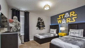 Et Star Wars-værelse med to senge, en Star Wars-plakat og en Stormtrooper-figur.