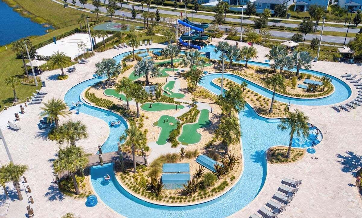 A resort with a large swimming pool, a water slide, and a golf course.