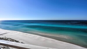 En strand med kristallklart turkosfärgat vatten och en sandstrand.