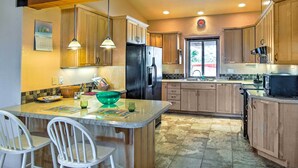 A kitchen with wooden cabinets, a refrigerator, a sink, and a window. - Borrego Springs Home w/ Desert & Mountain Views! (Borrego Springs)