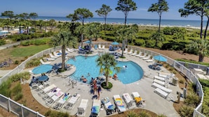 A pool area with multiple swimming pools, sun loungers, and umbrellas. - Breathtaking Ocean Views with Year-Round Heated Pool! (Hilton Head Island)